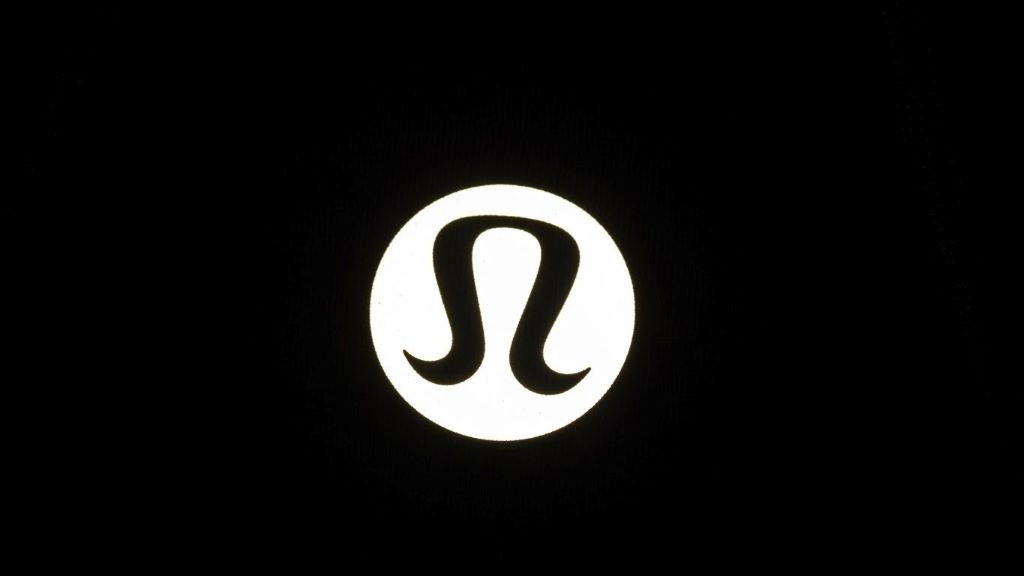 Close-up of authentic Lululemon reflective logo glowing bright white under camera flash showing even reflection pattern