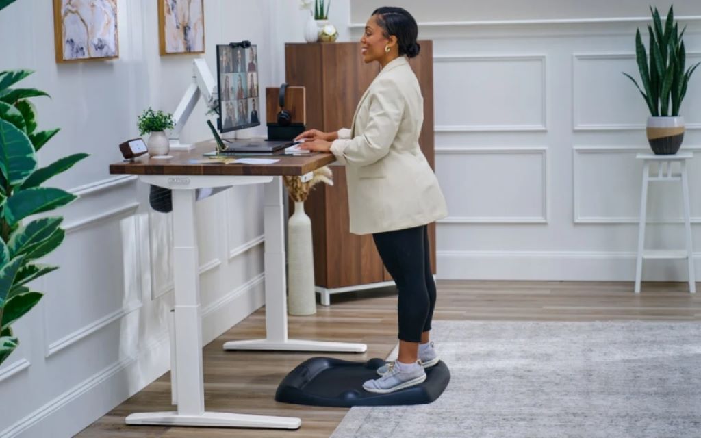 Professional using an adjustable standing desk for improved productivity and comfort